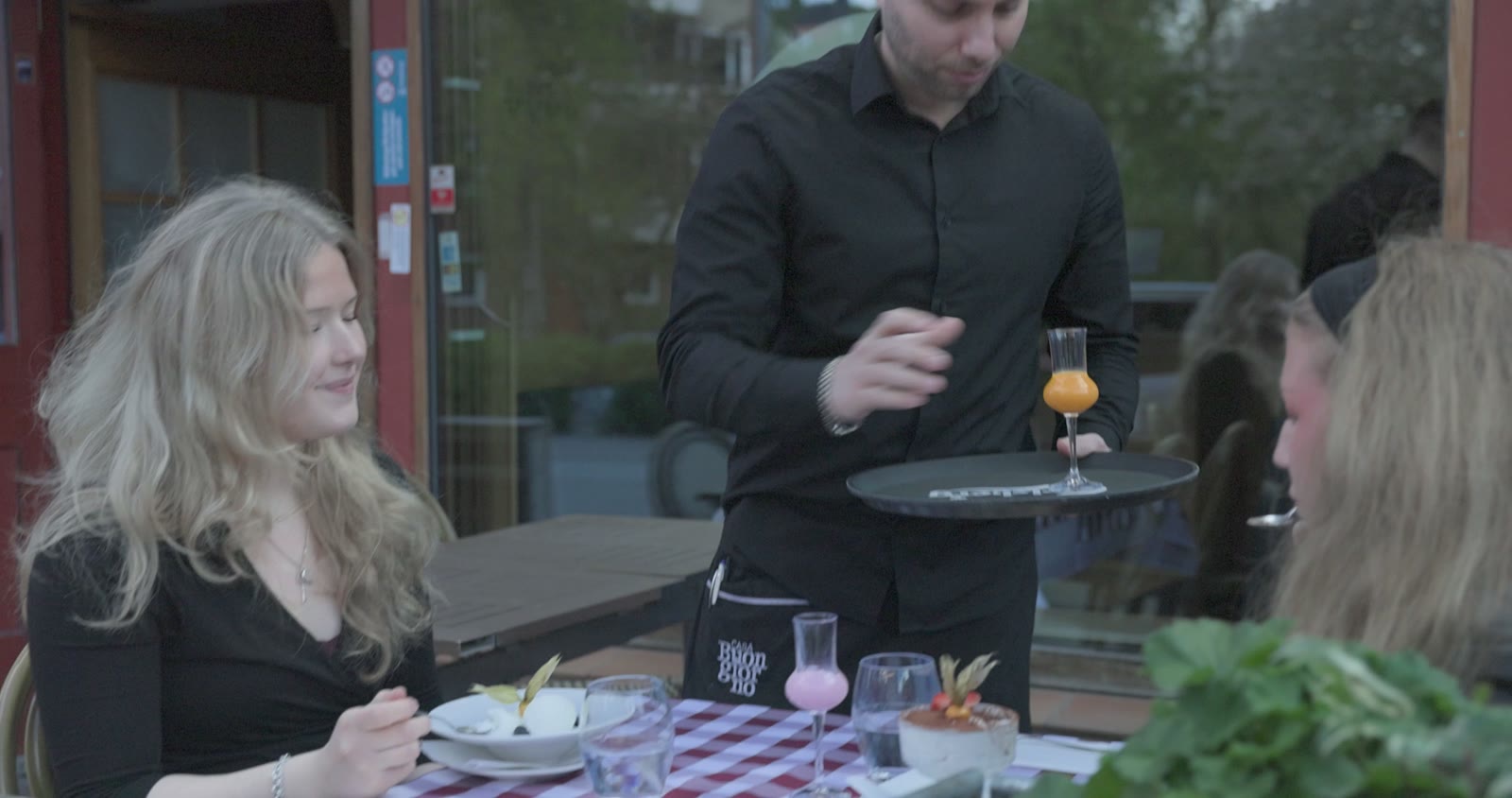 Waiter serving drinks at an outdoor restaurant table