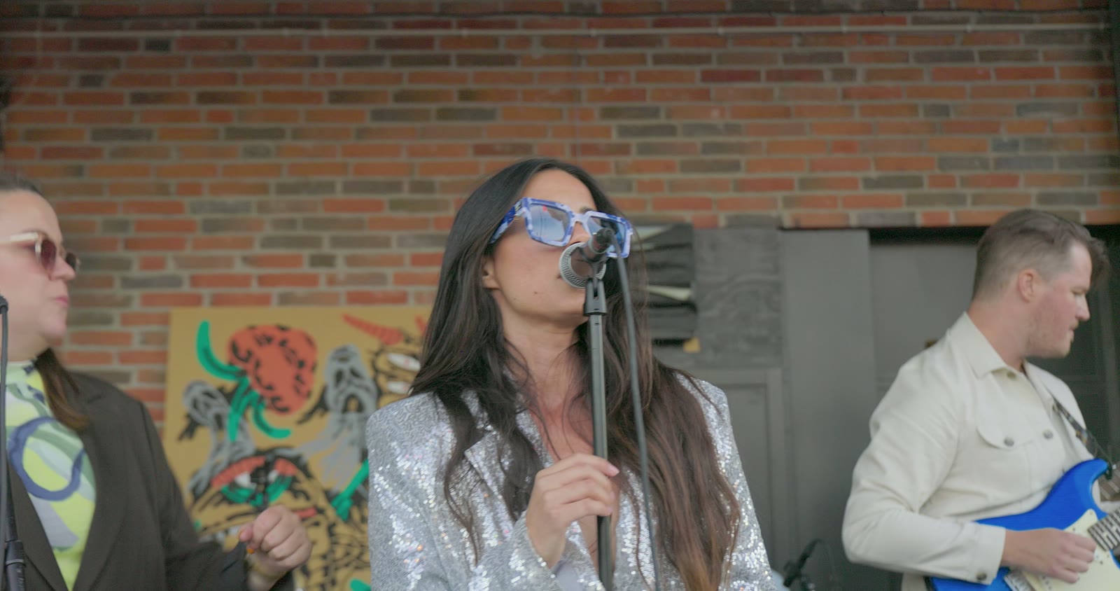 Singer performing with a live band outdoors